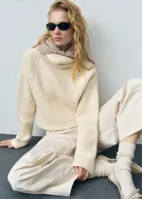 Sweater color crema de punto grueso con cuello alto.