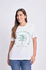 Remera blanca de algodón con estampa circular en el frente con una palmera y texto en verde.