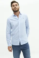 Camisa de lino color beige, de manga larga, corte semi slim y logo bordado en el pecho.