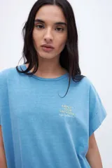 Musculosa celeste con estampado pequeño en el pecho, corte oversize y mangas con dobladillo.