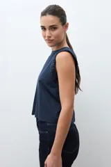 Blusa roja sin mangas, con cuello redondo y sisa drapeada.