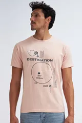 Camiseta de manga corta color rosa pálido, con cuello redondo y estampado gráfico en negro que incluye texto como "DESTINATION", "DAY DREAM" y "FUTURE SLOPES".