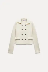 Chaqueta color crudo de tejido de punto con cuello solapa y manga larga. Tiene bolsillos de parche delanteros y cierre cruzado con doble botonadura.