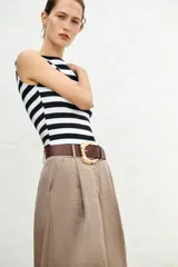 Camiseta sin mangas a rayas horizontales blancas y negras, con cuello barco y corte ajustado.