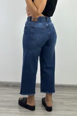 Pantalón jean azul oscuro, corte culotte, con tiro alto y terminación desflecada.