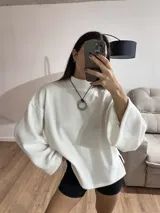 Sweater blanco de tela Aspen, cuello alto y mangas largas con puños acampanados.