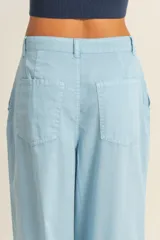 Pantalón palazzo color beige de tiro alto con pinzas y pierna ancha.