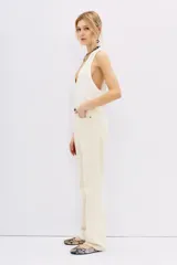 Pantalón de jean color crudo, de corte recto y tiro alto, con bolsillos delanteros y traseros.