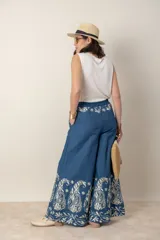 Pantalón italiano de jean azul con bordados florales en color crema. Tiene cintura elastizada con cordón ajustable y bolsillos laterales.