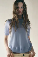 Top celeste de punto fino con cuello redondo y mangas cortas.