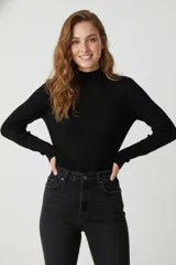 Polera negra de manga larga, cuello alto y corte ajustado al cuerpo, confeccionada en viscosa.