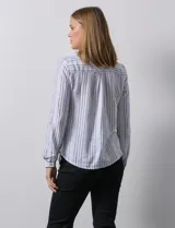 Blusa de lino a rayas verticales blancas y grises, marca Zac & Rachel. Tiene cuello a la base, escote en V y abertura central con botones. Cuenta con dos bolsillos en el pecho y mangas largas regulables con presilla y botón.