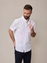 Camisa blanca de algodón de manga corta con cuello abotonado.