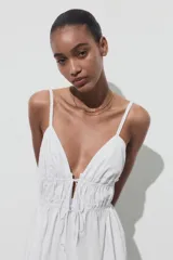 Vestido midi blanco de popelín con escote pico pronunciado, tirantes finos ajustables con cordones y detalle de frunces en la cintura.