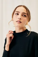 Polera negra de algodón y elastano, con cuello alto y mangas largas, corte ajustado al cuerpo.