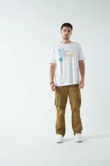 Remera blanca de algodón con estampado frontal de texto en azul y naranja. Corte clásico y cuello redondo.