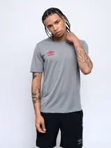 Remera deportiva gris de poliéster con logo de Umbro en rojo en el pecho.