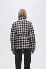 Campera puffer estampada a cuadros en blanco y negro con pequeños corazones rosados, cierre frontal con cremallera y bolsillos laterales.