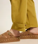 Pantalón balloon de sarga color verde oliva, con cintura alta, trabillas, cierre con botón y cremallera, bolsillos delanteros y detalle de martingale en la parte baja.