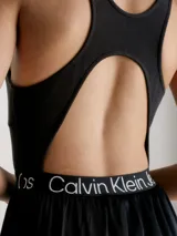 Vestido corto negro de Calvin Klein Jeans con corte evasé, breteles anchos y espalda deportiva. Presenta una banda elástica con el logo de la marca en la cintura.
