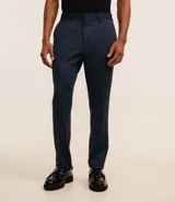 Pantalón de vestir azul marino, de corte recto, con bolsillos laterales y traseros. Se ajusta a la cintura con cinturón de cuero marrón.