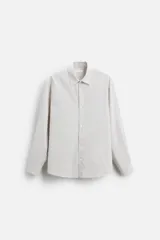 Camisa de hombre relaxed fit confeccionada en tejido de algodón a cuadros. Tiene cuello solapa, manga larga con puños abotonados, bolsillo en el pecho y cierre frontal con botones.