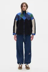 Campera de fleece combinada en texturas, con cuello subido, cierre delantero y bolsillos laterales.