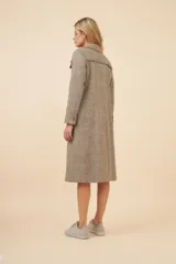 Tapado largo color beige con cuello solapa y corte recto. Cierre frontal con botones, detalles aplicados en la parte delantera, tajo en la espalda y bolsillos ojal con tapa. Con forro. Hecho en Uruguay con tela 100% lana fina sin teñir.