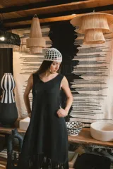 Vestido midi color marrón con textura y flecos en el ruedo, de breteles finos y corte holgado.