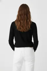 Polera de manga larga color blanco, de tejido de punto fino, con cuello tipo tortuga o cuello alto.