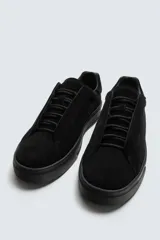 Zapatilla de hombre color negro, de estilo casual, con cordones y parte superior de piel con acabado serraje. Suela ligera a tono.