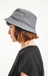 Gorro tipo bucket color gris oscuro con etiqueta con logo en el frente.