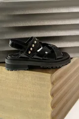 Sandalias negras de charol con tiras cruzadas y plataforma track.