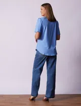 Blusa celeste de tejido piqué, con cuello a la base y escote en V. Tiene mangas cortas amplias.