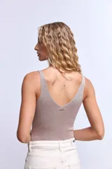 Pantalón de denim color crudo, corte ancho y tiro alto, con grandes calados florales bordados en contraste a lo largo de ambas piernas.