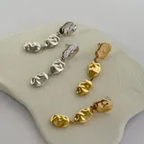 Aros colgantes dorados con tres piezas irregulares con textura martillada unidas por pequeñas argollas.