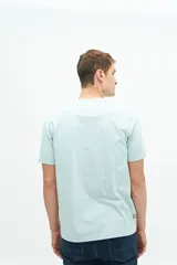 Remera verde agua de manga corta con estampado de dos peces y texto en azul marino.