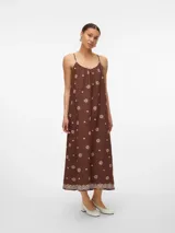 Vestido largo hasta la pantorrilla, color marrón oscuro, con tirantes finos y escote fruncido. Presenta un estampado repetitivo de círculos concéntricos en color beige claro, con un borde decorativo de encaje o puntilla en el ruedo.