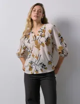 Blusa de gasa verde con estampado floral blanco y celeste, cuello a la base con escote en V y mangas 3/4 fruncidas.