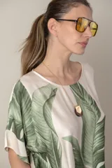 Blusa italiana color natural con estampado de hojas en tonos azules. De calce holgado y talle único.