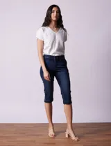 Pantalón capri blanco de algodón elastizado. Pretina con pasadores, botón y cierre. Delantera con bolsillos. Trasera con bolsillos simulados.