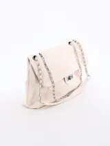 Cartera tipo bandolera color crema con textura acanalada, cadena plateada y cierre metálico.