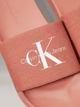 Ojotas color salmón con logo Calvin Klein Jeans en blanco.