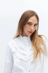 Camisa blanca de algodón con broderie y volados en cuello alto y puños.