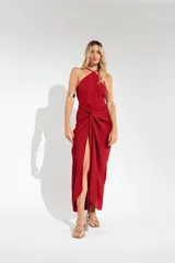 Vestido largo lila con escote halter cruzado en la espalda y falda tipo pareo con abertura lateral y nudo decorativo.