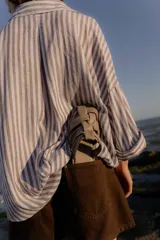 Sandalias tipo mule de cuero color marrón chocolate, con diseño de tiras anchas cruzadas y suela plana.