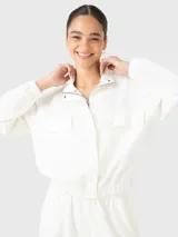 Buzo blanco de tela suave y ligera con bolsillos en la parte frontal, con cierre y tape con botones para hacerlo invisible; y pretina en la cintura que le dan un estilo ondero y moderno.
