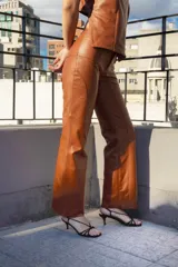 Pantalón de cuero color marrón con costuras verticales en el frente.