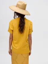 Remera amarilla de corte cuadrado y holgado, con estampado de estrella plateada con borde negro en el frente.