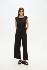 Mono negro de poliéster y lurex, corte recto, con cuello redondo y cinturón de lazo.